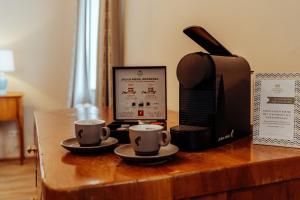 two cups of coffee on a wooden table with a printer at Der Schlosswirt zu Anif - Biedermeierhotel und Restaurant in Anif