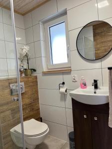 a bathroom with a toilet and a sink and a mirror at Pod Gwiazdami in Władysławowo