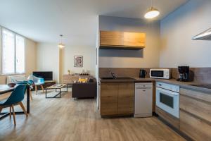 a kitchen with a counter and a table with chairs at Entre Terre et Mer - Coeur d'une cité de caractère in Pontrieux