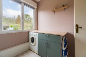 a laundry room with a washing machine and a window at Entre Terre et Mer - Coeur d'une cité de caractère in Pontrieux