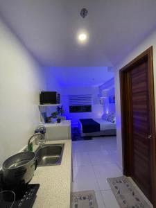 eine Küche mit einem Waschbecken und ein Zimmer mit einem Bett in der Unterkunft LR COZY STUDIO in Cebu City