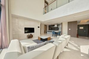 a living room with white furniture and a flat screen tv at Y Collection by UH FLAT Daegu in Daegu