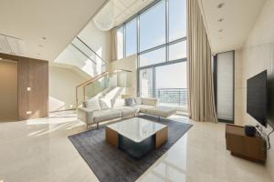 una sala de estar con un sofá y una mesa en UH FLAT Signature DAEGU, en Daegu