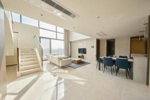 Una sala de estar con un sofá, una mesa y sillas. en UH FLAT Signature DAEGU, en Daegu