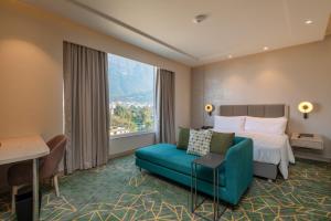 una camera d'albergo con letto, divano e finestra di Holiday Inn Katra Vaishno Devi, an IHG Hotel a Katra