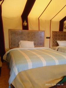 a bedroom with two beds in a room at Désert Man luxury Camp in Merzouga