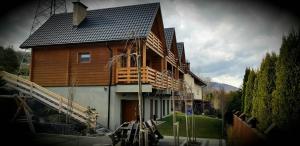 a large wooden house with a deck on the side of it at Górska Pasja Wisła in Wisła