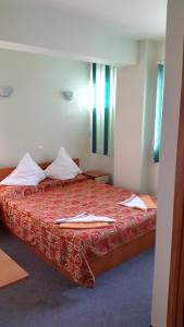 1 dormitorio con 1 cama con colcha roja en Complex Europa L.G, en Ploieşti