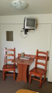 una camera con tavolo, due sedie e una TV a parete di Complex Europa L.G a Ploieşti