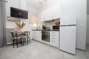a kitchen with a table and a white refrigerator at Celestina Corfu Town Apartment in Corfu