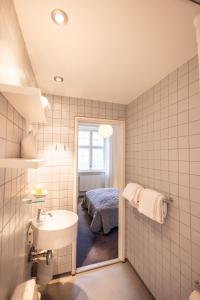 ein Bad mit einem Waschbecken und ein Bett in einem Zimmer in der Unterkunft Konventum Conference Center in Helsingør