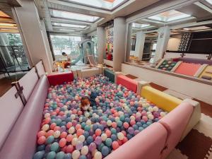 a baby in a pool of balls in a room at Hotel De Khuvieng in Chiang Mai