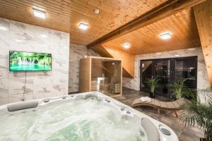 duża łazienka z wanną i telewizor na ścianie w obiekcie Południk Park Boutique Hotel Conference&SPA w mieście Stargard