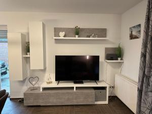 uma sala de estar com uma grande televisão de ecrã plano em Annalena´s Ferienhaus Hooksiel em Wangerland