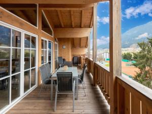 drewniany ganek ze stołem i krzesłami w obiekcie Luxury penthouse in Brixen im Thale with Parking w mieście Brixen im Thale