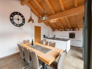 kuchnia i jadalnia z drewnianym stołem i krzesłami w obiekcie Luxury penthouse in Brixen im Thale with Parking w mieście Brixen im Thale