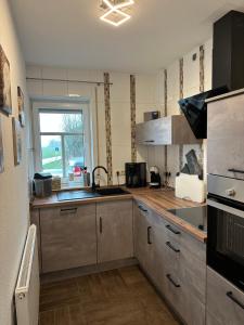 uma cozinha com um lavatório e um fogão em Annalena´s Ferienhaus Hooksiel em Wangerland