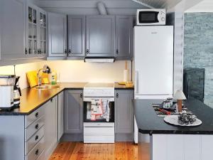 cocina con armarios grises y nevera blanca en 6 person holiday home in Tengelfjord, en Tengelfjorden