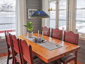 uma sala de jantar com uma mesa de madeira com cadeiras vermelhas em Holiday Home Raften em Tengelfjorden