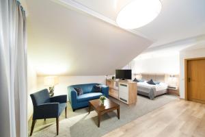 ein Wohnzimmer mit einem Bett und einem Sofa in der Unterkunft Hotel Restaurant Bullerdieck in Garbsen