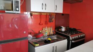 czerwona kuchnia ze zlewem i kuchenką w obiekcie Arriendo casa vista al mar w mieście Las Cruces