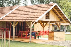 a large wooden house with a table and chairs at Glamping na podeželju 