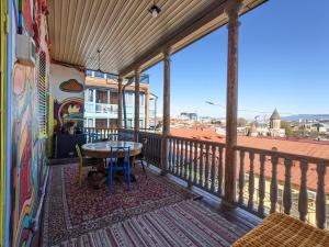balcón con mesa y vistas a la ciudad en Namaste Hostel en Tiflis
