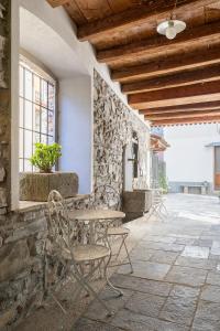 a patio with chairs and a table and a stone wall at Cadepulan in Como