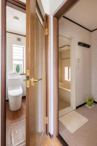 een open deur naar een badkamer met een toilet bij Dat's house in Tokyo