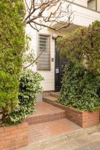 a house with a brick walkway leading to a black door at Dat's house in Tokyo