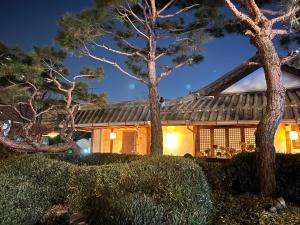 a house with a chinese roof at night at Sungsim Hanok Guesthouse in Jeonju