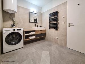 ein Badezimmer mit einer Waschmaschine und einem Waschbecken in der Unterkunft St. Antoni Suite 2 in Eisenstadt