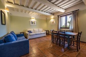 uma sala de estar com uma mesa e um sofá em Rosaspina - Appartamento 1 em Capalbio