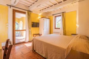 um quarto com uma cama num quarto com paredes amarelas em Rosaspina - Appartamento 1 em Capalbio