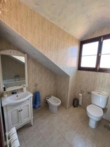 uma casa de banho com um lavatório, um WC e um espelho. em Chalet Adosado en exclusiva urbanización em Comillas