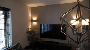 sala de estar con TV de pantalla plana en la pared en 't Sand Apartment, en Zandvoort