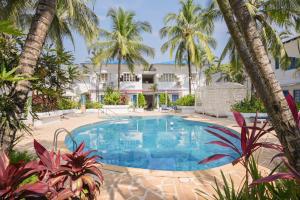 ein Pool vor einem Haus mit Palmen in der Unterkunft Soul Vacation Resort and Spa,Colva in Colva