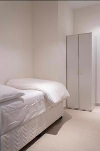 a white bedroom with a bed and a cabinet at شقة فاخرة في فندق العنوان Two bedrooms apartment at address residences in Sharm