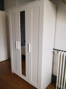 armadio bianco con porta in camera di Chambres cosy dans une maison meulière de charme a Saint-Maur-des-Fossés