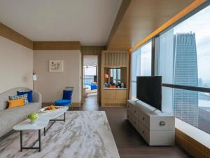 a living room with a tv and a large window at MGM Shanghai West Bund in Shanghai
