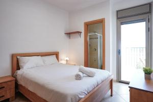 a bedroom with a white bed and a large window at Shoham Sea and Soul in Eilat