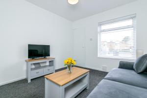 a living room with a couch and a tv at Fairlands lodge in Stevenage