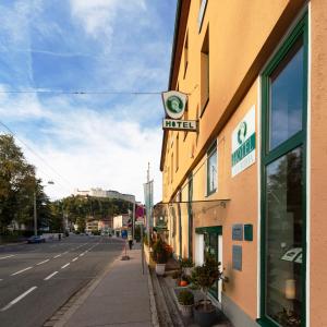 een gebouw met een bord aan de straatkant bij Hotel Via Roma in Salzburg