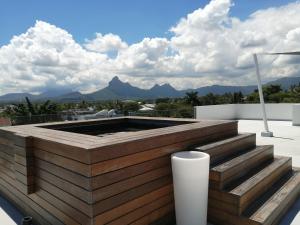 a fire pit on a roof with mountains in the background at Superbe appartement avec vue mer et montagnes. in Tamarin