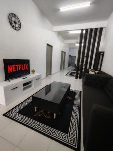 a living room with a couch and a tv at Homestay Temerloh Near Hospital Wi-Fi Netflix in Temerloh