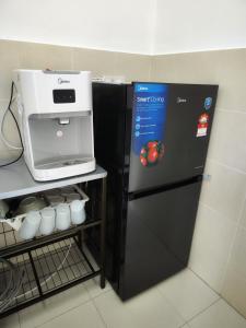 a black refrigerator with a coffee machine on top of it at Homestay Temerloh Near Hospital Wi-Fi Netflix in Temerloh