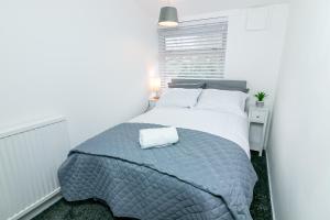 a white bedroom with a bed and a window at Fairlands lodge in Stevenage
