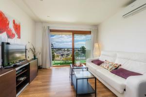 un soggiorno con divano bianco e TV di Apartamento Vista Mar a Alcudia