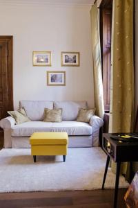 a living room with a couch and a yellow stool at Rhythm and style in Prague city center Andel in Prague