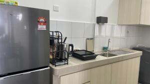 a kitchen counter with a sink and a refrigerator at AJ Family Work Sandakan Homestay Blue Horizon in Sandakan